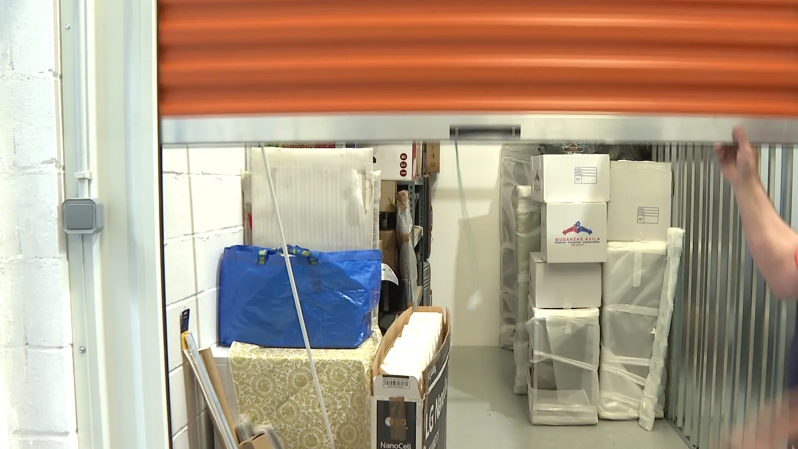 Trastero con muebles protegidos con plástico y cajas
