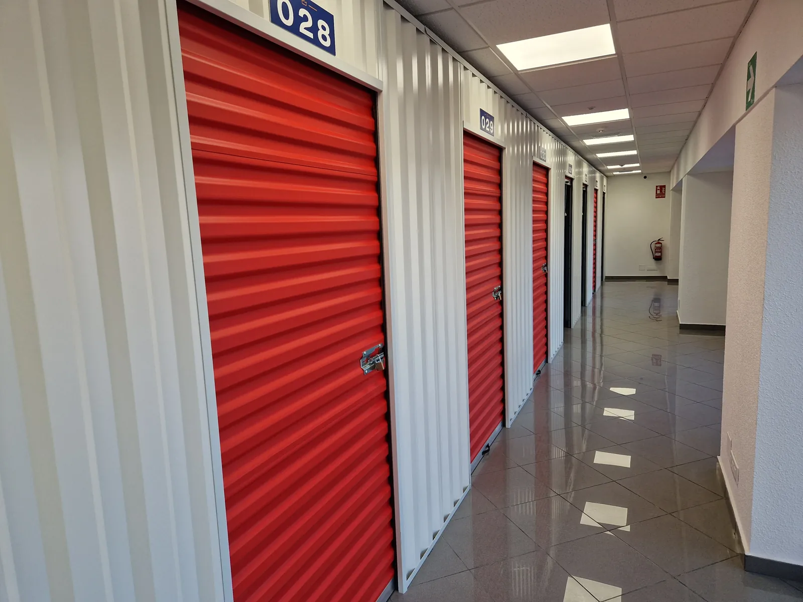 Pasillo de trasteros con persianas rojas